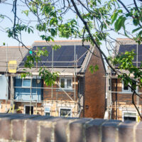Homes with rooftop solar panels and scaffolding at Penderi
