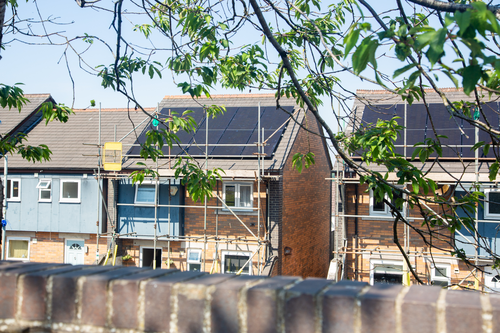 Homes with rooftop solar panels and scaffolding at Penderi